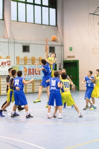 Jacopo, in maglia gialla, salta per la palla a due di Moncalieri-CUS Torino al torneo "La Befana gioca a basket" (foto Matteo Della Malva)